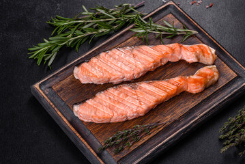 Grilled salmon with herbs served on black concrete table