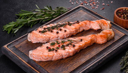 Grilled salmon with herbs served on black concrete table