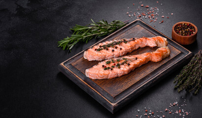 Grilled salmon with herbs served on black concrete table