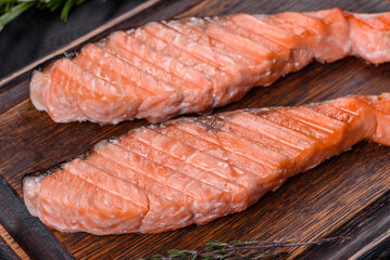 Grilled salmon with herbs served on black concrete table