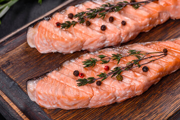 Grilled salmon with herbs served on black concrete table
