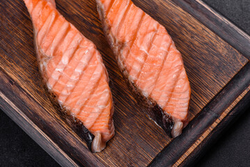 Grilled salmon with herbs served on black concrete table