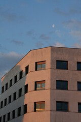 Sunrise building with reflection on windows and blue sky with some clouds