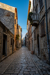 Fototapeta na wymiar Empty, old, stone paved narrow streets of Rovinj, popular tourist destination with beautiful, colorful houses in the Istrian region of Croatia