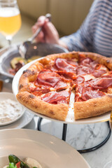 Delicious Parma Ham and Pepperoni Pizza. Dinner at Italian Restaurant