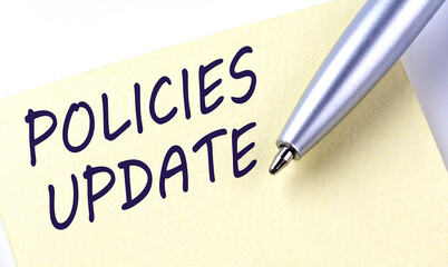 Sticky Note Message POLICIES UPDATE with pen on white background
