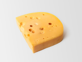 Piece of Maasdam cheese with large holes on a light background