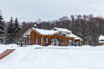 Wooden building made of cylindrical timber in the winter city park