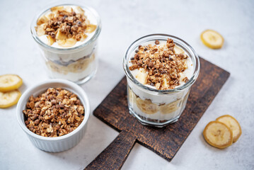 Banana Greek yogurt chocolate granola parfait in a glass