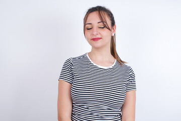 Obraz premium young Arab woman wearing striped t-shirt over white background nice-looking sweet charming cute attractive lovely winsome sweet peaceful closed eyes