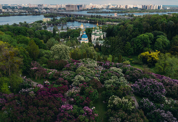 panorama beautiful top view of Kiev beautiful green park with purple flowers church near the river with a bridge on the city background on a sunny day, overall plan