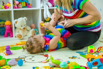 Fototapeta premium Baby plays in the room with her mother. Selective focus.