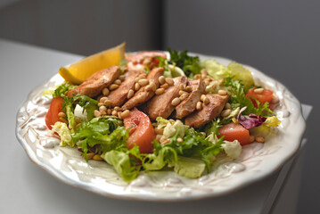 Salad with tomato chicken, pine nuts and lemon