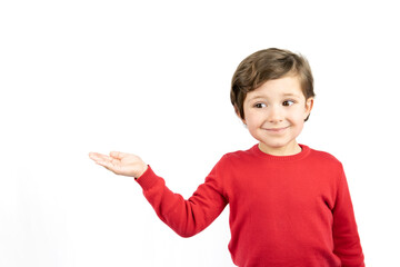 Little boy in red sweater pointing with hand on white background.