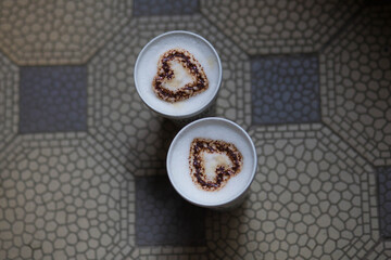 Cute romantic cup of coffee with dark chocolate on retro tile floor from above