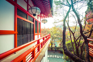 Fototapeta na wymiar Traditional Japanese temple architecture in a forest with fall colors in daylight.