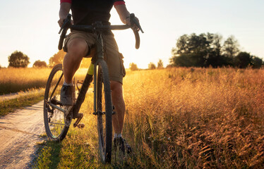 Fototapeta na wymiar Professional cyclist rides on a dirt road on a sunny summer day.