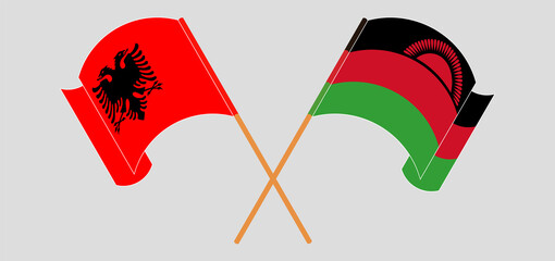 Crossed and waving flags of Albania and Malawi