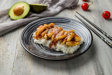 chicken in teriyaki sauce with rice on grey wooden table