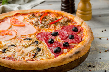 Pizza four seasons on grey wooden table macro close up