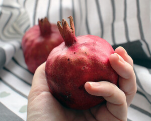 Ripe pomegranate in hand. Juicy red fruit. 