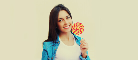 Summer portrait of beautiful happy smiling young brunette woman with lollipop
