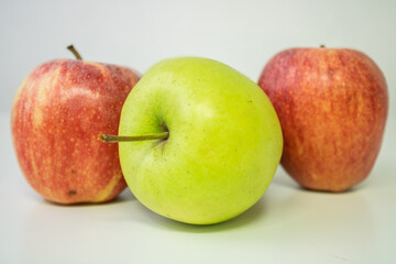 2 red aplle with one green apple in midle