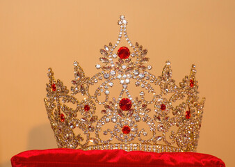 beautiful crown with red stones on a red pillow