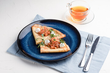 Pancakes with red fish, pancakes with fish on a white background, Russian cuisine