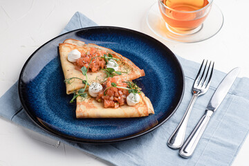 Pancakes with red fish, pancakes with fish on a white background, Russian cuisine
