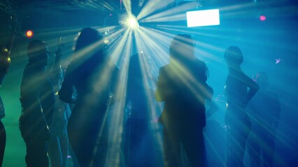 Youth enjoying weekend evening at disco. Dancing under abstract light effects. Nightlife, modern music and entertainment concept. - Powered by Adobe