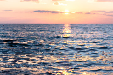 Sunset sun and waves close-up. Orange colors of the low sun in the Mediterranean Sea.