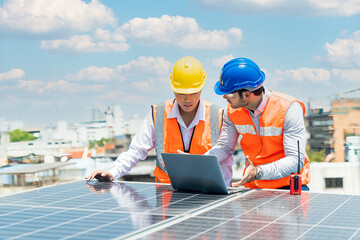 A technician or electrical engineer is teaching an apprentice to work. Foreman and Worker maintaining solar energy panel.