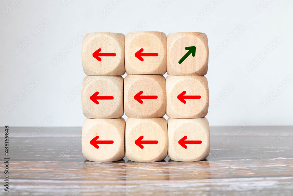 Aufkleber one of arrow move to opposite direction with others arrow which carved on wooden block.