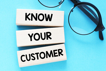 Fototapeta premium KNOW YOUR CUSTOMER words on wooden blocks and a blue background.