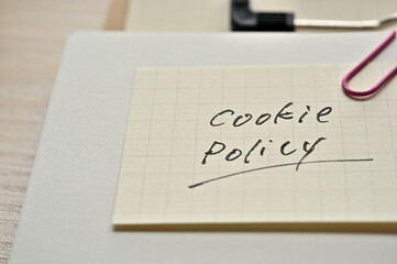 A piece of paper clipped to the edge of the notebook has Cookie Policy.