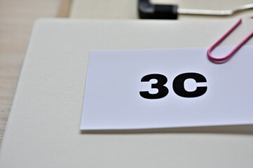 A piece of paper clipped to the edge of the notebook has 3C written on it. It is an abbreviation for customer, competitor, company.