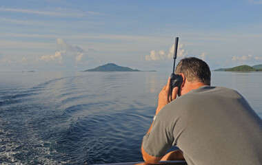 Man using satellite phone at sea.
