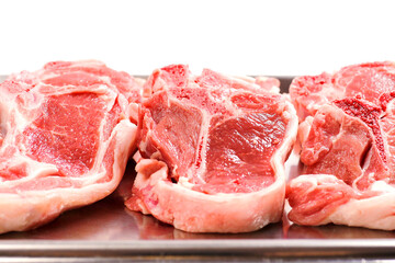 Stack of fresh lamb loin chops. Close up. Meat industry. The product is on a metal tray, Butcher craft.