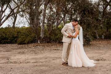 Bride and Groom kissing with greenery in the background 