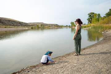 Fototapeta na wymiar Mother and daughter at the shore of a small lake, Colorado
