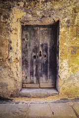 An old medieval door with rusty metal fittings in Mdina