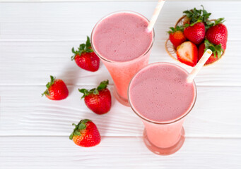 Strawberry yogurt fruit juice smoothie pink colorful fruit juice milkshake blend beverage healthy high protein the taste yummy In glass drink episode morning on white wood background.