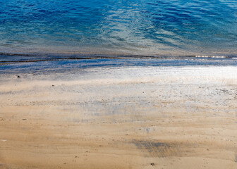 Close up of gentle waves lapping against the shore.