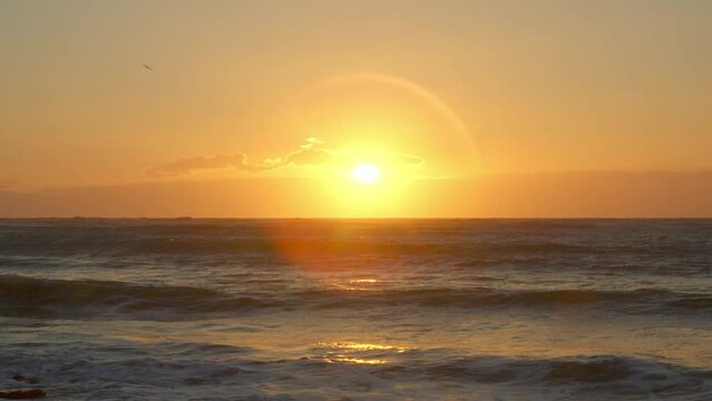 Dramatic sunset sunrise over a wavy sea