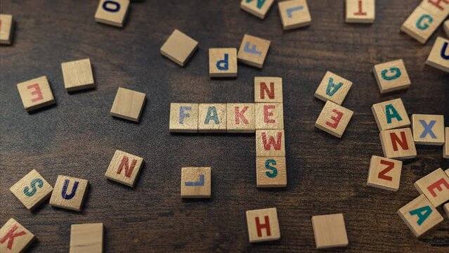 Fake News concept - phrase spelled from the wooden cubes on tabletop - zooming shot. High quality 4k footage