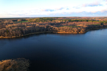 Lake on sunset in autumn season. Aerial panoramic landscape view of lake in village of Staroselye, Chashniki region, Belarus. Drone view of lake in spring. Aerial view of wetland in fall colors..