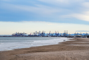 Fototapeta premium Coastline of Patacona beach overlooking Cabanyal beach and Malvarossa and seaport of Valencia. Empty beach and no peaple in spain during a pandemic. Sea with storm waves in winter season at resort..