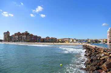 Fototapeta premium Coastline Alboraya beach with colourful house and building in Port Saplaya. Travel on touristic famous and popular Beaches of Valencia with unique landscape on Mediterranean Sea.