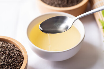 Perilla oil and seeds in bowl on white background, Healthy herbal seed ingredients in Asian food